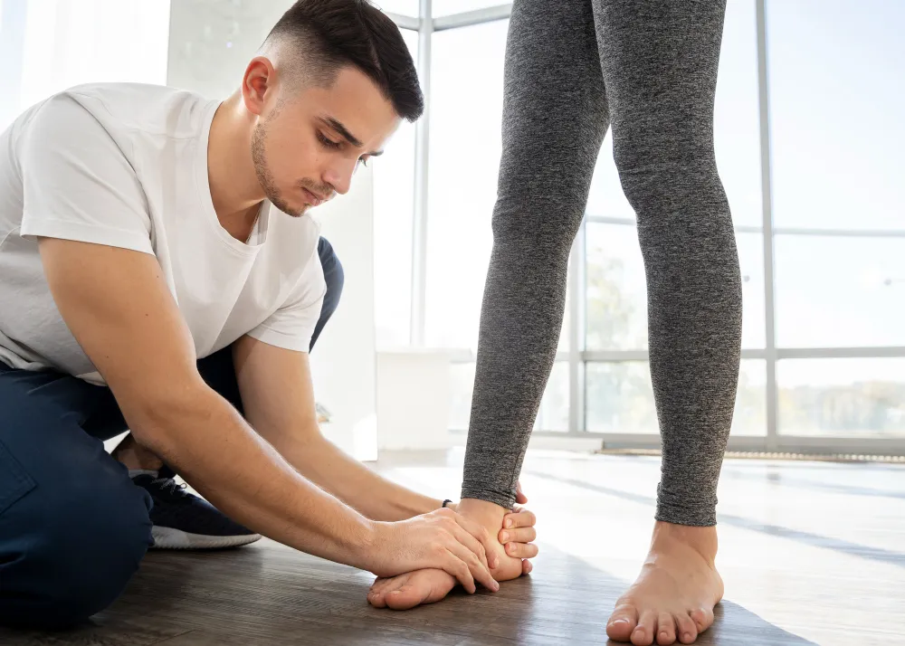 Podiatrist examining a patient's foot during a biomechanical assessment for PTTD